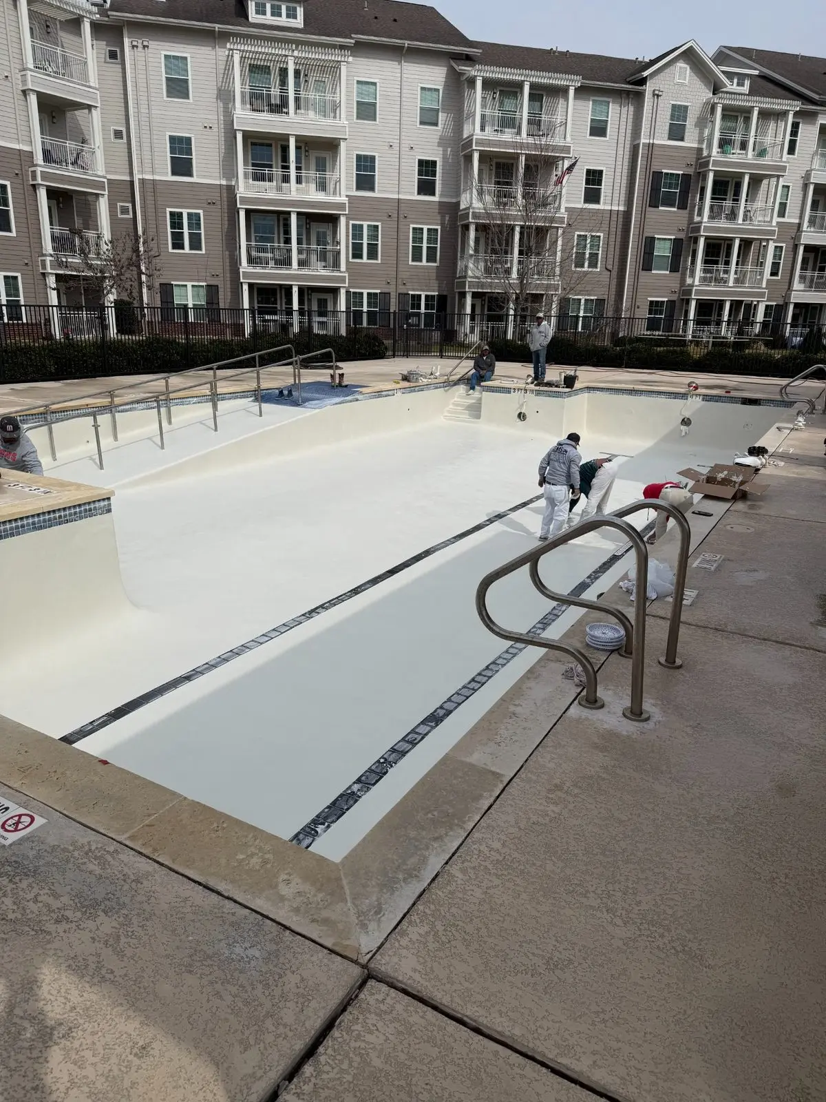 Commercial swimming pool replastering crew applying a new interior finish