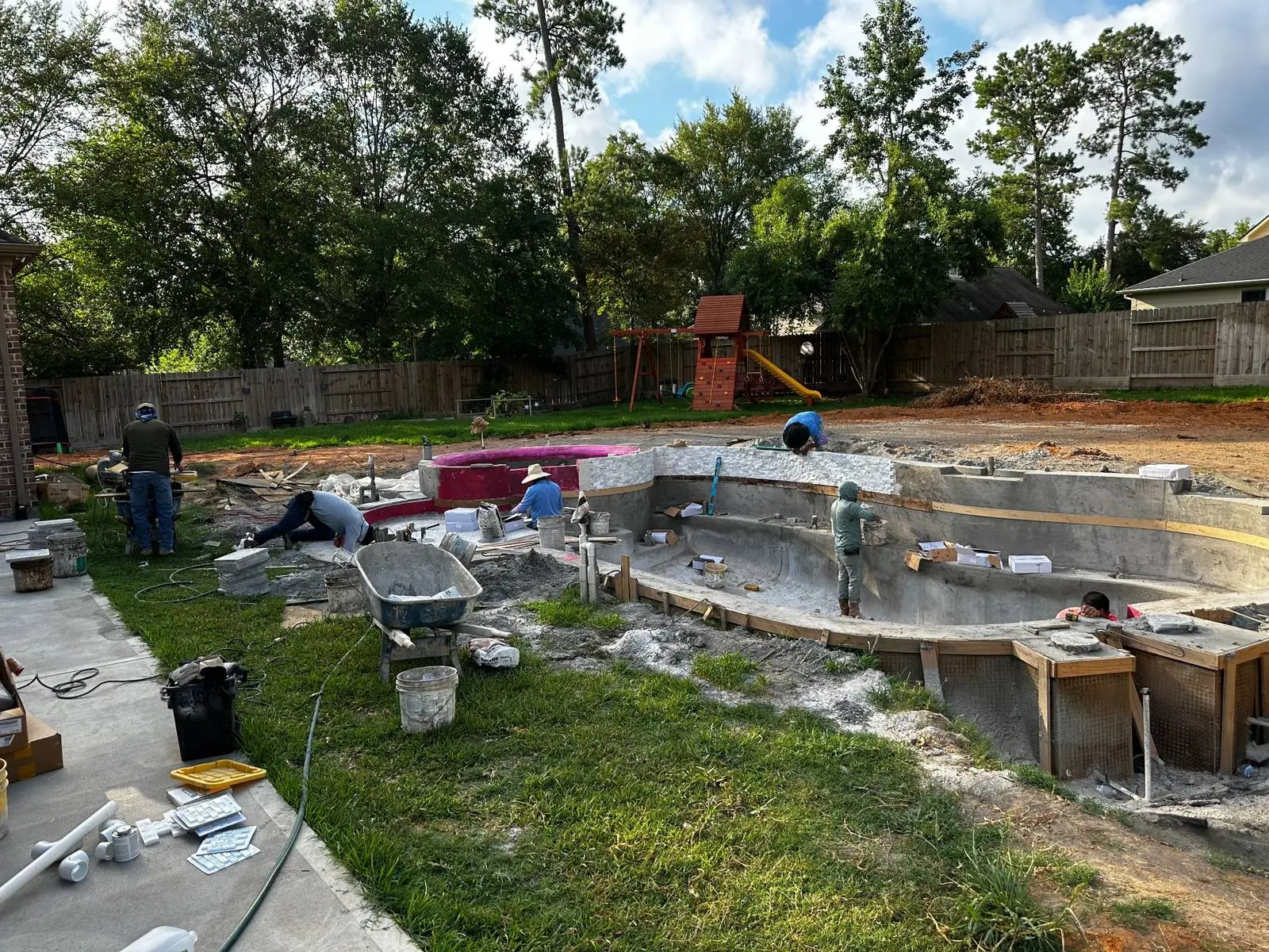 Pool remodel crew installing new tile and coping